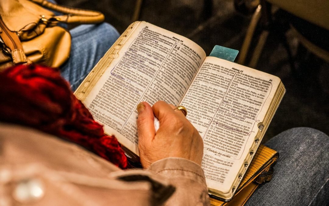 A person reading a Bible indoors, symbolizing spirituality and devotion.