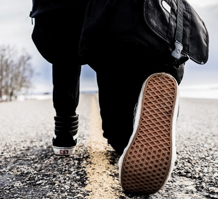 person kneeling right leg on road during daytime